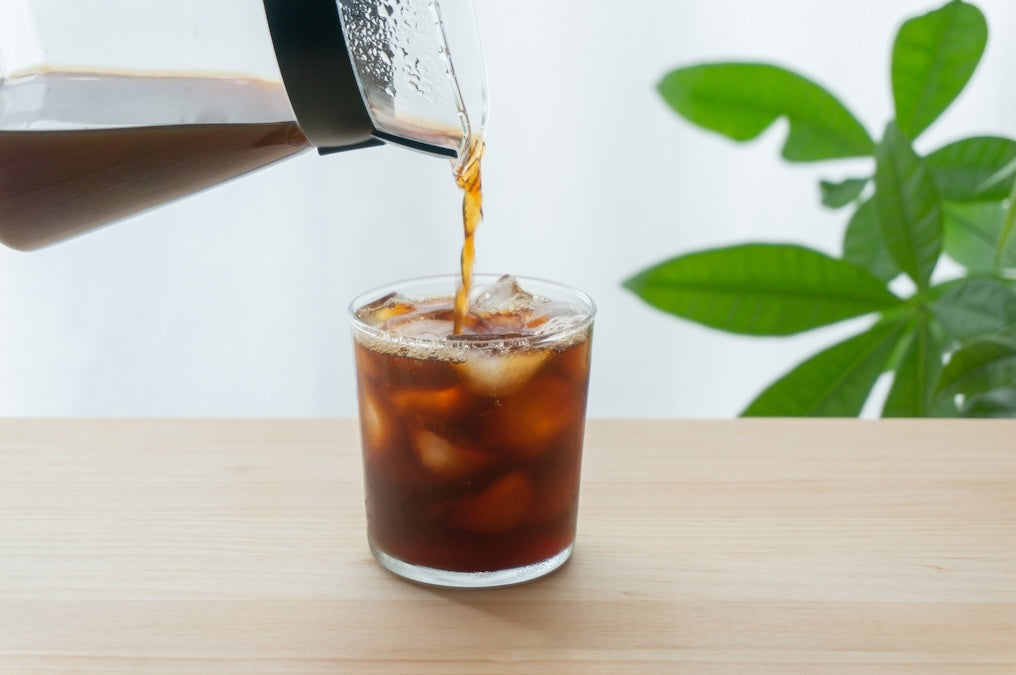 カラフェから氷を入れたグラスへ、水出しコーヒーを注いでいるところ
