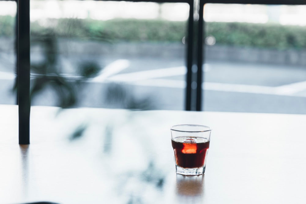 窓際に置いたアイスコーヒーのグラス